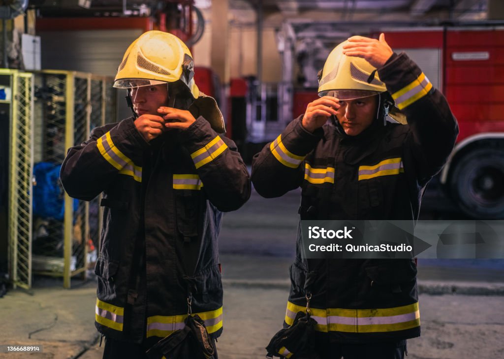 Firemen Portrait Of Two Young Firemen In Uniform Standing Inside The Fire ...