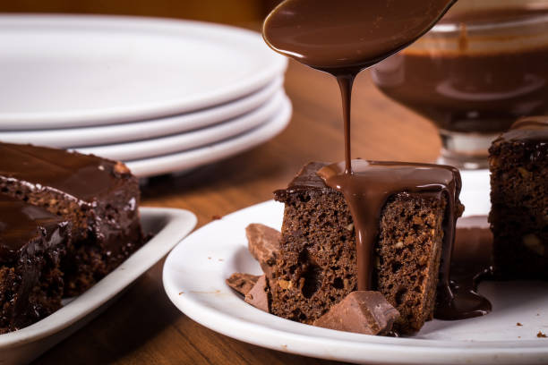 brownie avec sauce au chocolat sur assiette blanche sur table en bois - nappage photos et images de collection