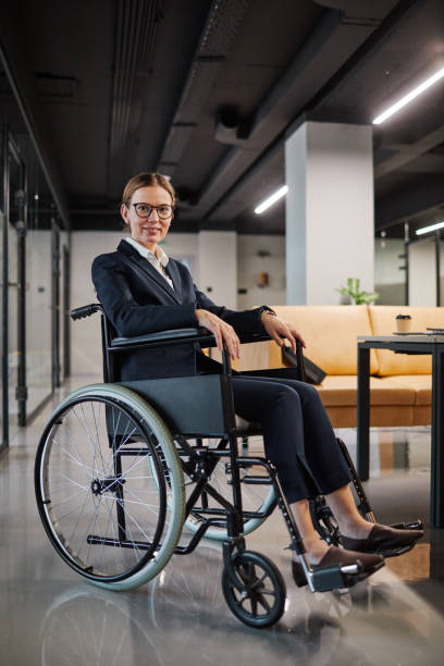 istock Successful Businesswoman using Wheelchair in Modern Office 1366691282