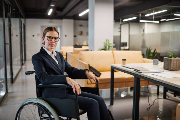 istock Businesswoman using Wheelchair in Modern Office 1366691283
