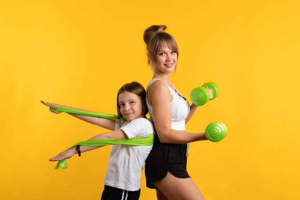 Mom and daughter workouts in studio stock photo