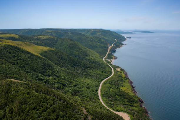 Aerial view of the winding Cabot Trail road Aerial view of the winding Cabot Trail road seen from high above on the Skyline Trail in Cape Breton Island, Nova Scotia cabot trail stock pictures, royalty-free photos & images