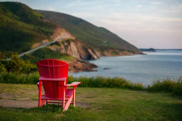 Photo of Red Adirondack chair facing the Cabot Trail