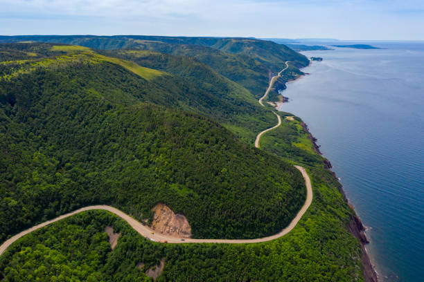 Aerial view of the winding Cabot Trail road Aerial view of the winding Cabot Trail road seen from high above on the Skyline Trail in Cape Breton Island, Nova Scotia cabot trail stock pictures, royalty-free photos & images