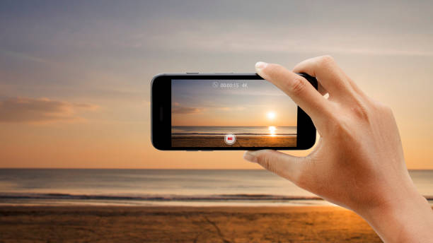 istock Shooting video of sunset beach by smartphone. 1366706583