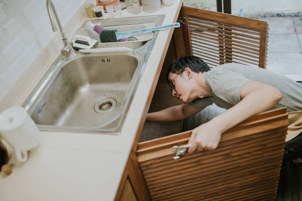 istock Asian Male Plumber Using Wrench To Fix Leaking Sink 1366706631