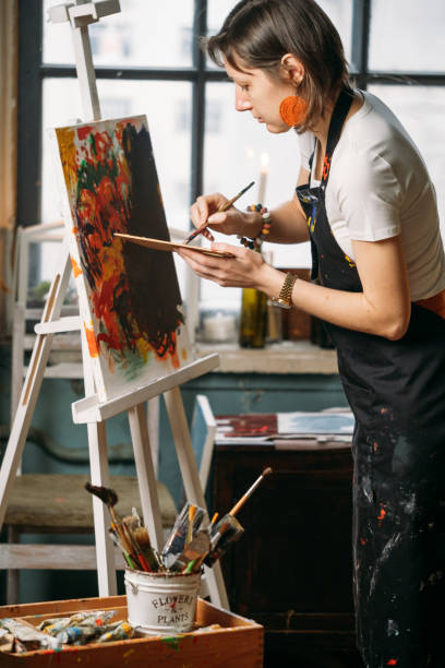 istock Woman artist creating canvas with paint in studio 1366707538