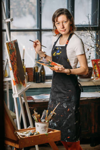 istock Woman artist creating canvas with paint in studio 1366708307