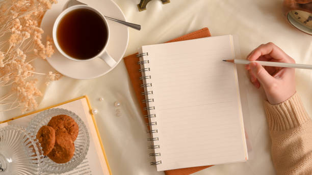 istock Overhead shot, A female in cozy sweater sketching on notebook paper. 1366709978
