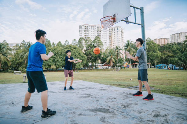 поколение z азиатский китайский подросток разминает упражнение перед тем, как заявить об игре на баскетбольной площадке утром в выходные д� - pass the ball стоковые фото и изображения