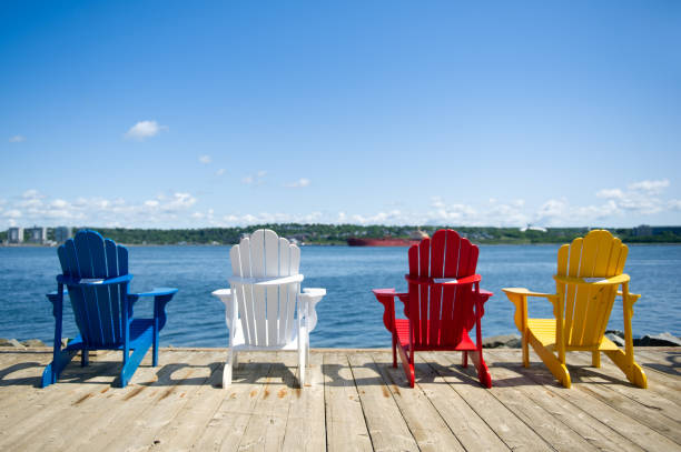 Colorful Adirondack chairs along the waterfront stock photo