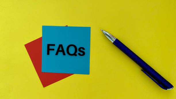 istock FAQs text on blue post it note with pen and yellow background. Business concept. 1366713025
