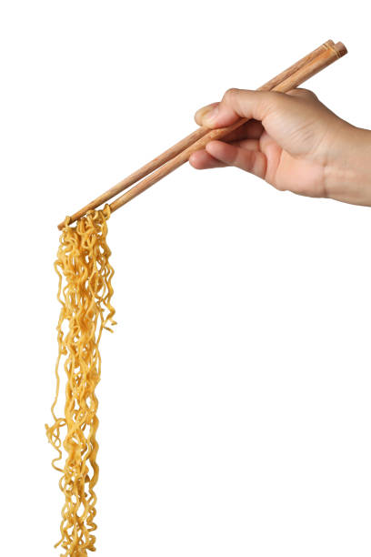 Hand holding chopsticks and noodles on white background stock photo