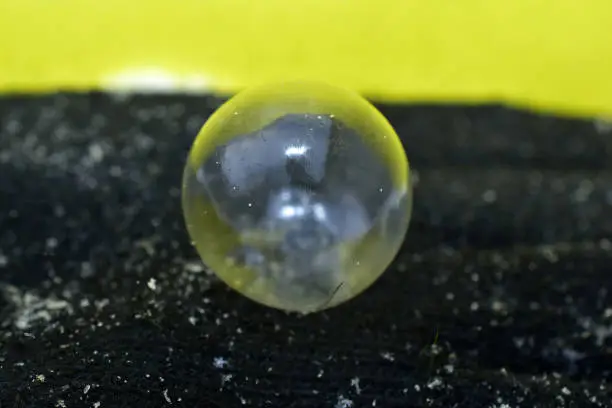 An ideally shaped transparent soap ball is covered with drawings and freezes in the cold.