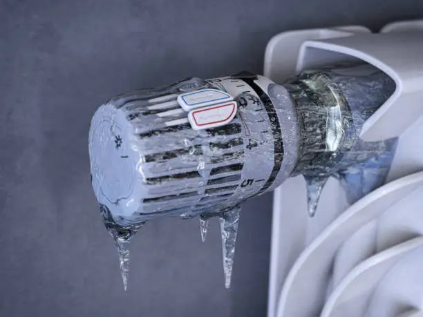 Photo of Thermostatic radiator valve with icicles. Energy crisis, sturning off heating for non-payment and saving concept.