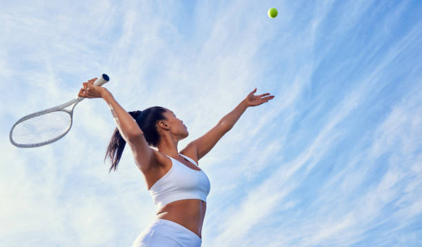 ujęcie atrakcyjnej młodej kobiety grającej w tenisa na zewnątrz - action tennis women tennis racket zdjęcia i obrazy z banku zdjęć