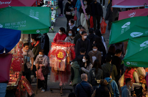 sous la propagation de la variante omicron, les gens vont toujours sur un marché de rue en achetant des ornements du nouvel an chinois et d’autres produits à la tête du prochain nouvel an lunaire chinois 2022 - crowd kowloon peninsula multi colored photos et images de collection