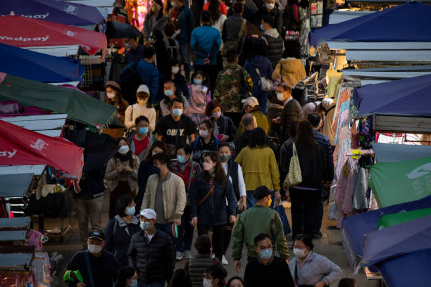 sous la propagation de la variante omicron, les gens vont toujours sur un marché de rue en achetant des ornements du nouvel an chinois et d’autres produits à la tête du prochain nouvel an lunaire chinois 2022 - crowd kowloon peninsula multi colored photos et images de collection