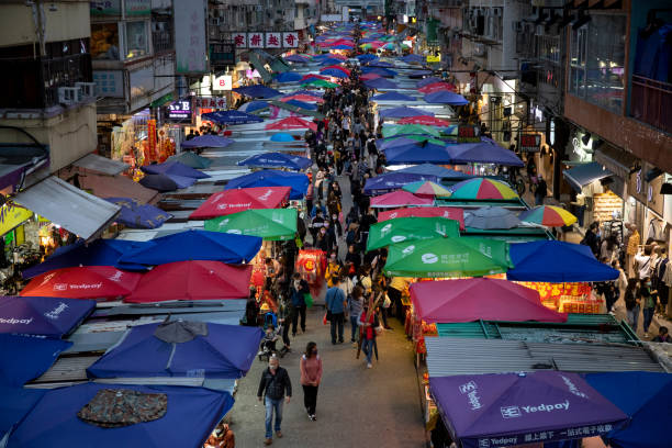 sous la propagation de la variante omicron, les gens vont toujours sur un marché de rue en achetant des ornements du nouvel an chinois et d’autres produits à la tête du prochain nouvel an lunaire chinois 2022 - crowd kowloon peninsula multi colored photos et images de collection