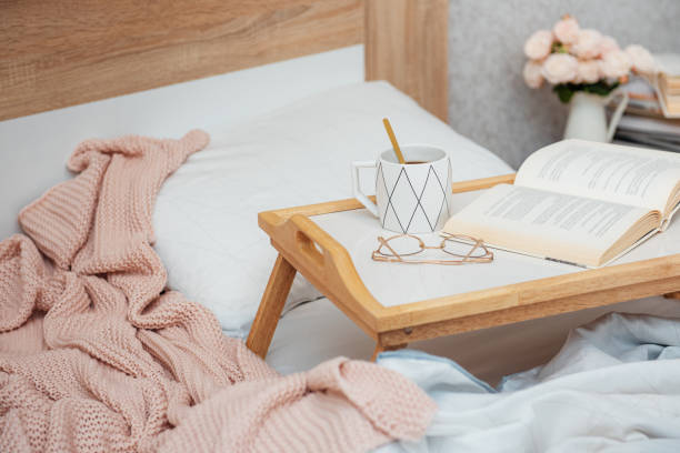 istock Cup of coffee and book on bed 1366722663