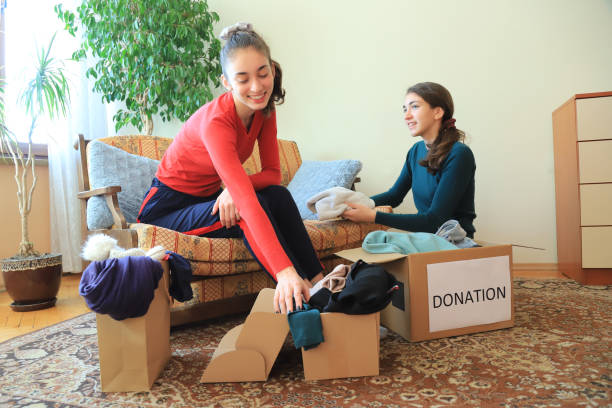 istock Two girls packing clothes for donation 1366722704