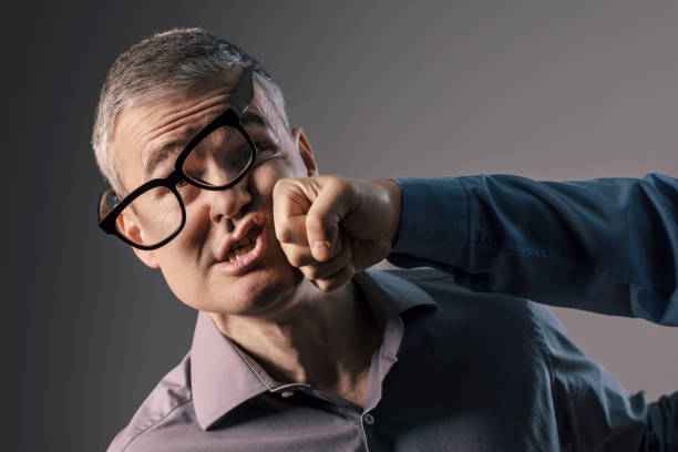 Man getting hit by a punch Man with glasses getting hit by a punch, violence and fight concept rough hands man stock pictures, royalty-free photos & images