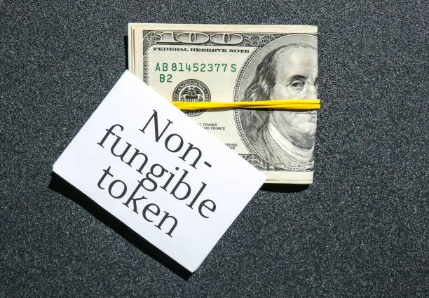 NFT non-fungible token text. Concept words NFT non-fungible token on paper blank. Background of dollar bills. Blockchain asset crypto art, digital art, new type of cryptorurrency Money against future of new virtual and future texto de token no fungible nft. palabras conceptuales nft token no fungible en papel en blanco. antecedentes de los billetes de dólar. blockchain activo cripto arte, arte digital, nuevo tipo de criptorurrenia dinero contra futuro de nuevo virtual