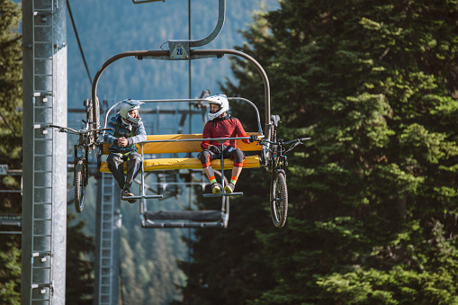 Mountain bikers on a chair lift.