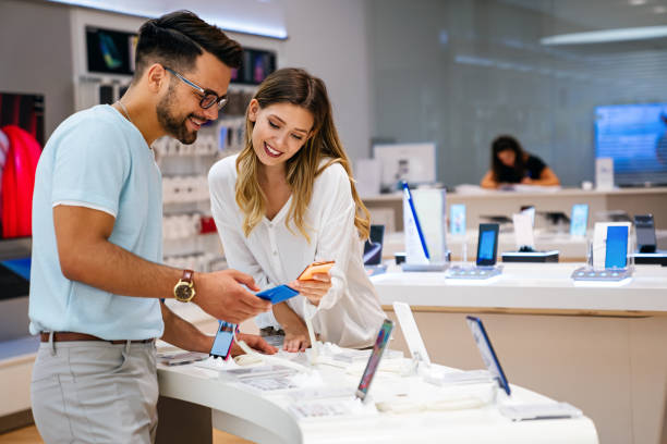 Shopping a new digital device. Happy couple buying a smartphone in store. stock photo