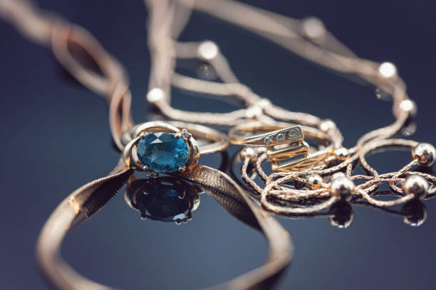 istock Gold rings with different precious stones lie surrounded by beautiful gold chains 1366731858