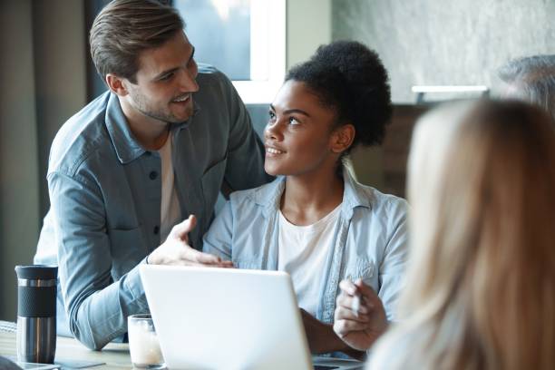 istock Smiling diverse colleagues discuss financial statistics, coworkers have cooperating working together at office meeting 1366732205