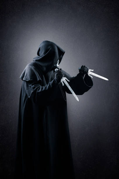 istock Hooded assassin with two daggers in the dark 1366732363