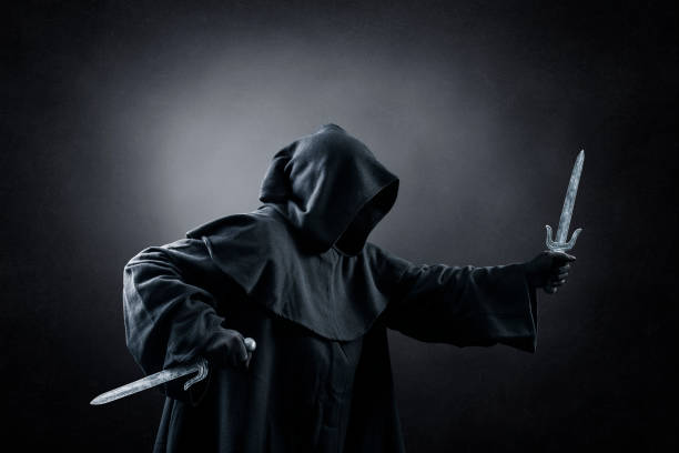 istock Hooded assassin with two daggers in the dark 1366732915