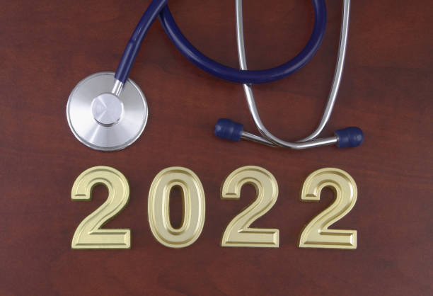 istock Stethoscope and numbers 2022 on wooden table. 1366733471