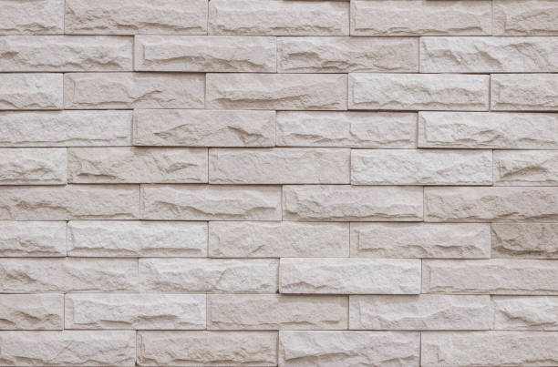 istock Cream and beige brick wall texture background. Brickwork and stonework flooring interior rock old pattern clean concrete grid uneven bricks office design. Background of old vintage brick wall backdrop 1366735592