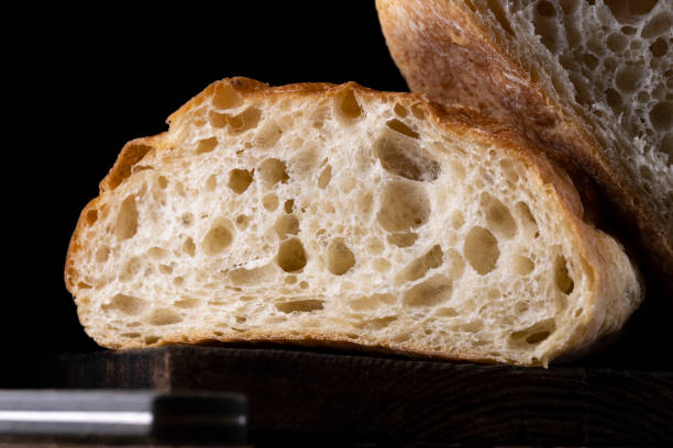 istock Fresh Baked Bread Cut in Half on a black background 1366737880