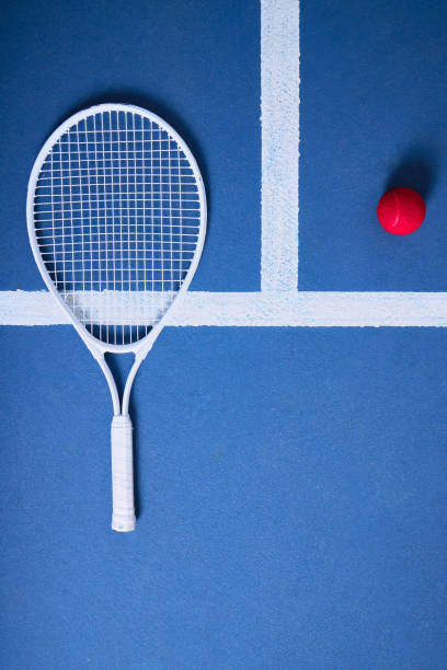 disparo de una pelota de tenis y una raqueta sobre un fondo azul - tennis indoors court ball fotografías e imágenes de stock
