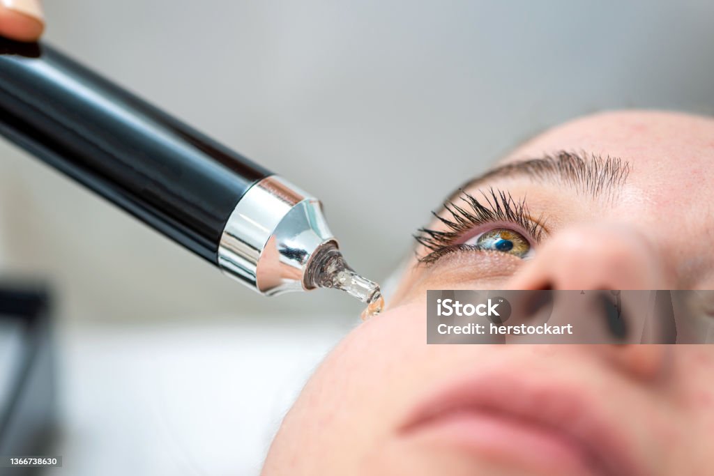 Cosmeteologist applying under eye patches to woman in beauty salon Eye Stock Photo