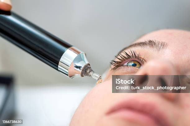 Cosmeteologist Applying Under Eye Patches To Woman In Beauty Salon Stock Photo - Download Image Now