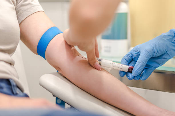 Close-up Of Doctor Taking Blood Sample From Patient's Arm in Hospital for Medical Testing. stock photo