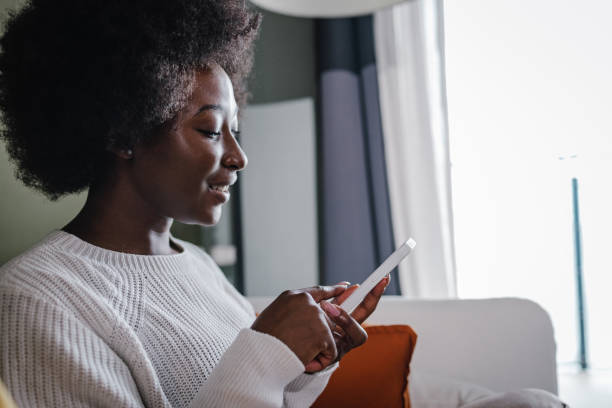 istock A young African-American woman using a mobile phone at home 1366739600