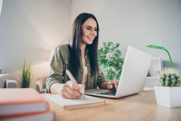 istock Portrait of charming cheerful girl working remotely making notes developing e-commerce at home house flat indoor 1366742910