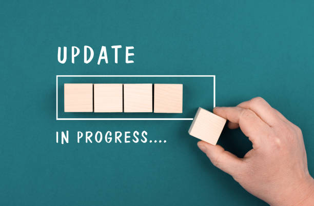 istock The words update in progress are standing beside the loading bar, hand puts last cube to the upload, petrol colored background 1366744471