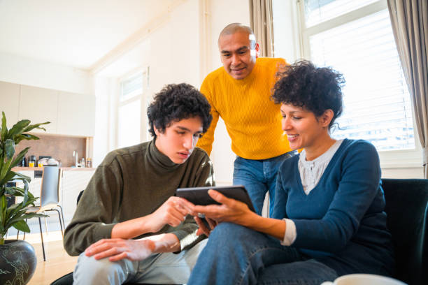 istock Hispanic Family Using Digital Tablet Together in Living Room 1366746053