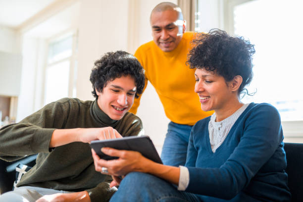 istock Hispanic Family Using Digital Tablet Together in Living Room 1366746054
