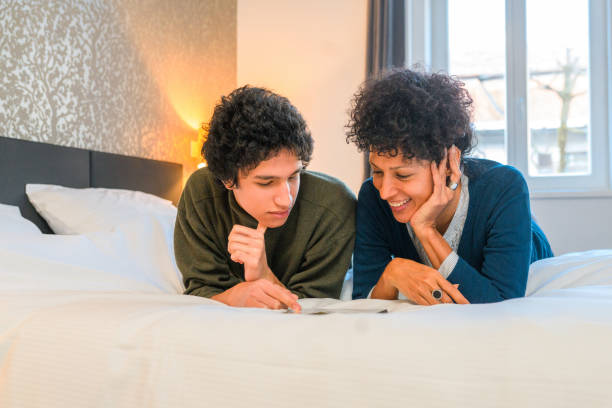 istock Hispanic Mother And Son Lying in Bed and Using Digital Tablet 1366746062