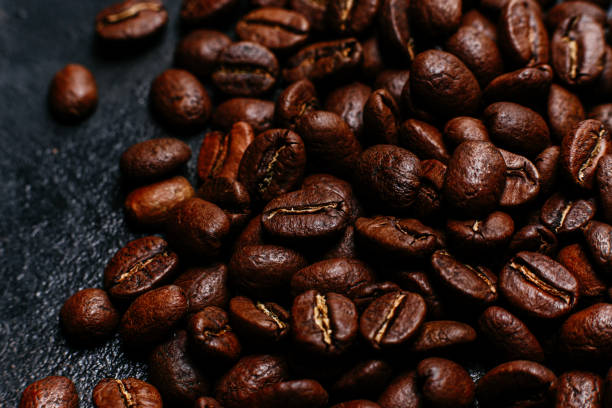 istock Roasted coffee beans close-up on a dark background. Colombian coffee 1366746761