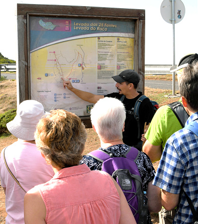 Madeira, Portugal - February 2016: Tour guide explaining the route of a walk to a group of tourists.