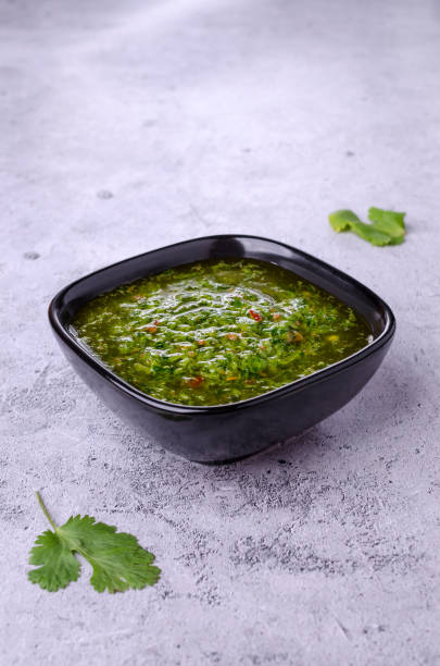 Green sauce in ceramic dishes Green sauce in ceramic dishes on a gray stone background. Selective focus.Green sauce in ceramic dishes on a gray stone background. Selective focus. Top view. chimichurri stock pictures, royalty-free photos & images