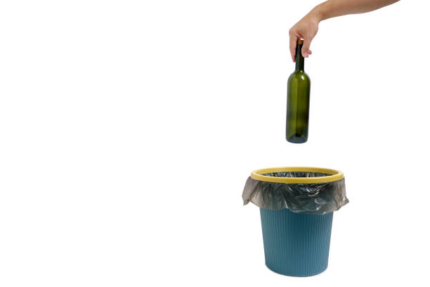istock In hand, an empty glass wine bottle is thrown into trash. 1366752338